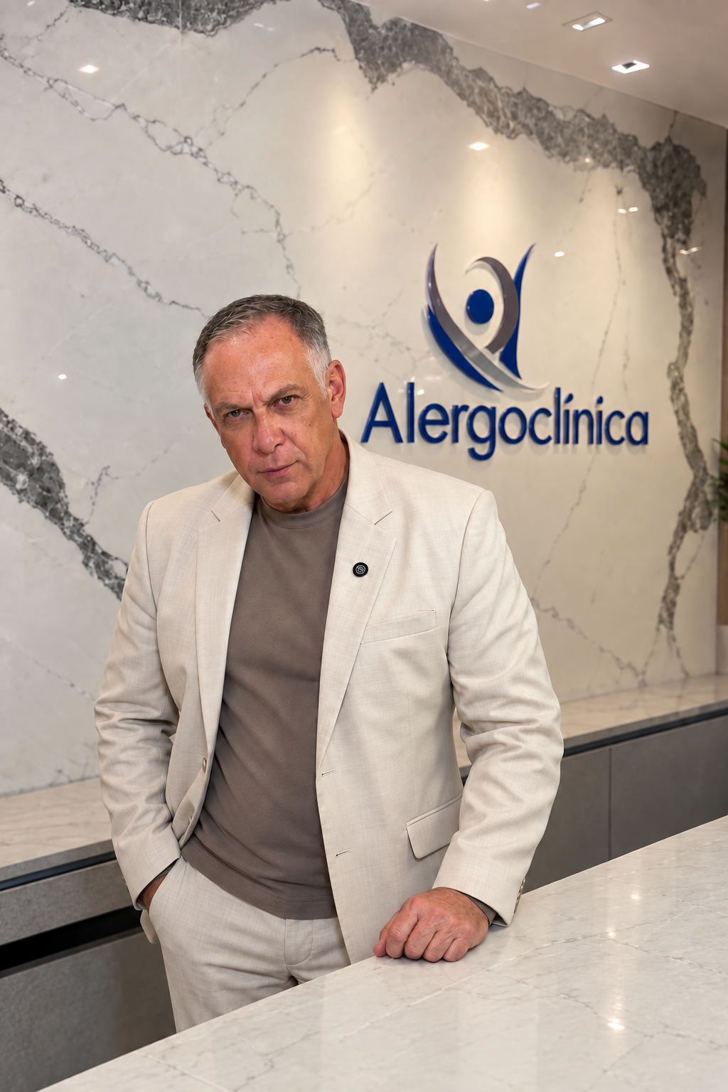 Dr. Luiz Melo diante da parede com o nome da Alergoclínica.